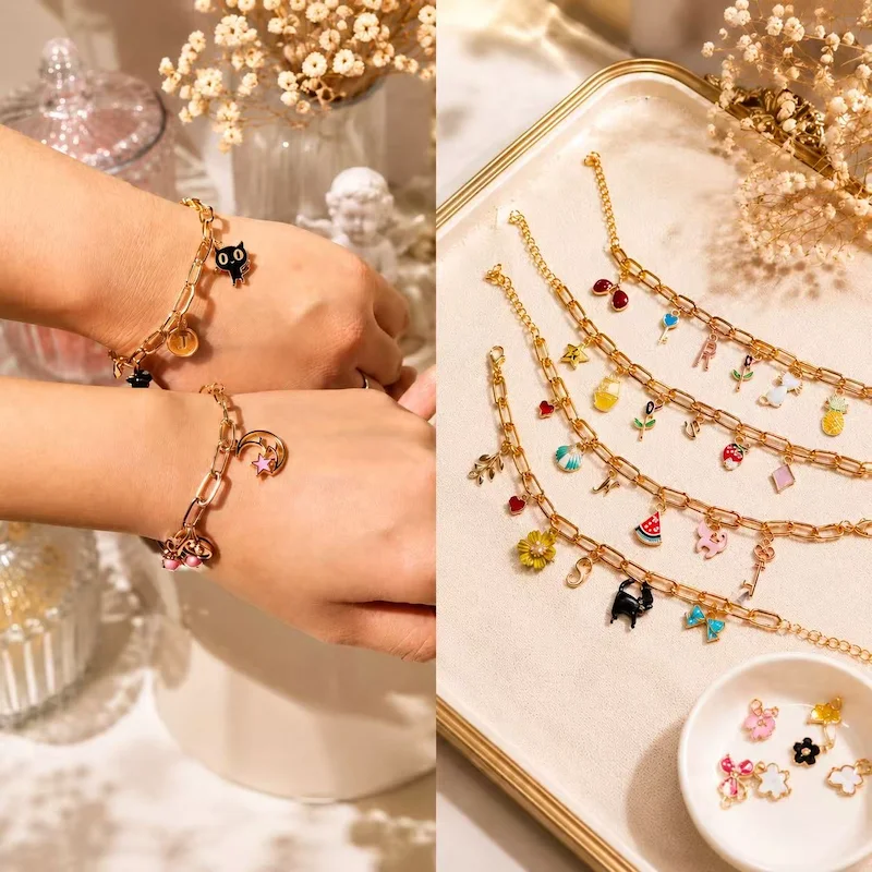 Gold charm bracelets with enamel fruit, animal, and initial charms
